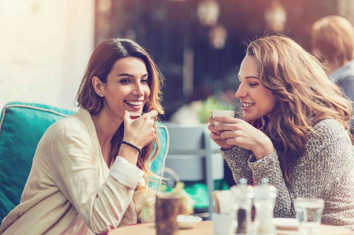 Two women talking in an outdoor cafe.