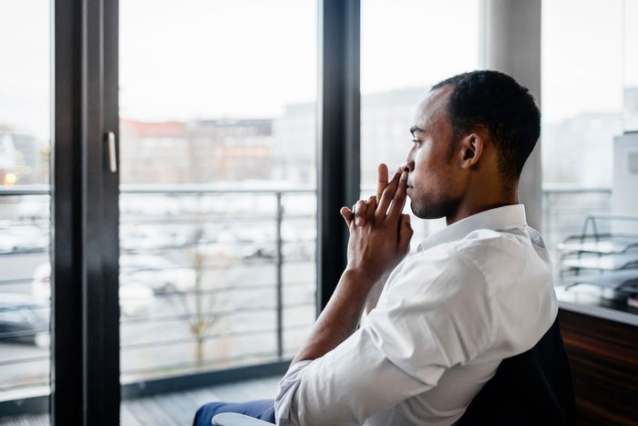 man sitting in chair looking out window