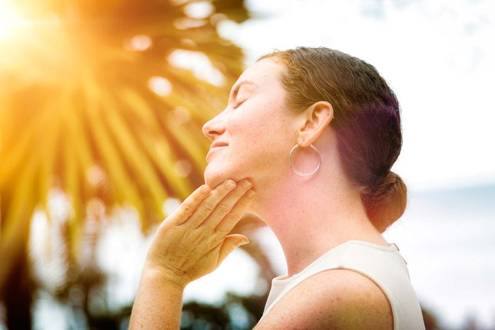 woman applying sunscreen to face and chin
