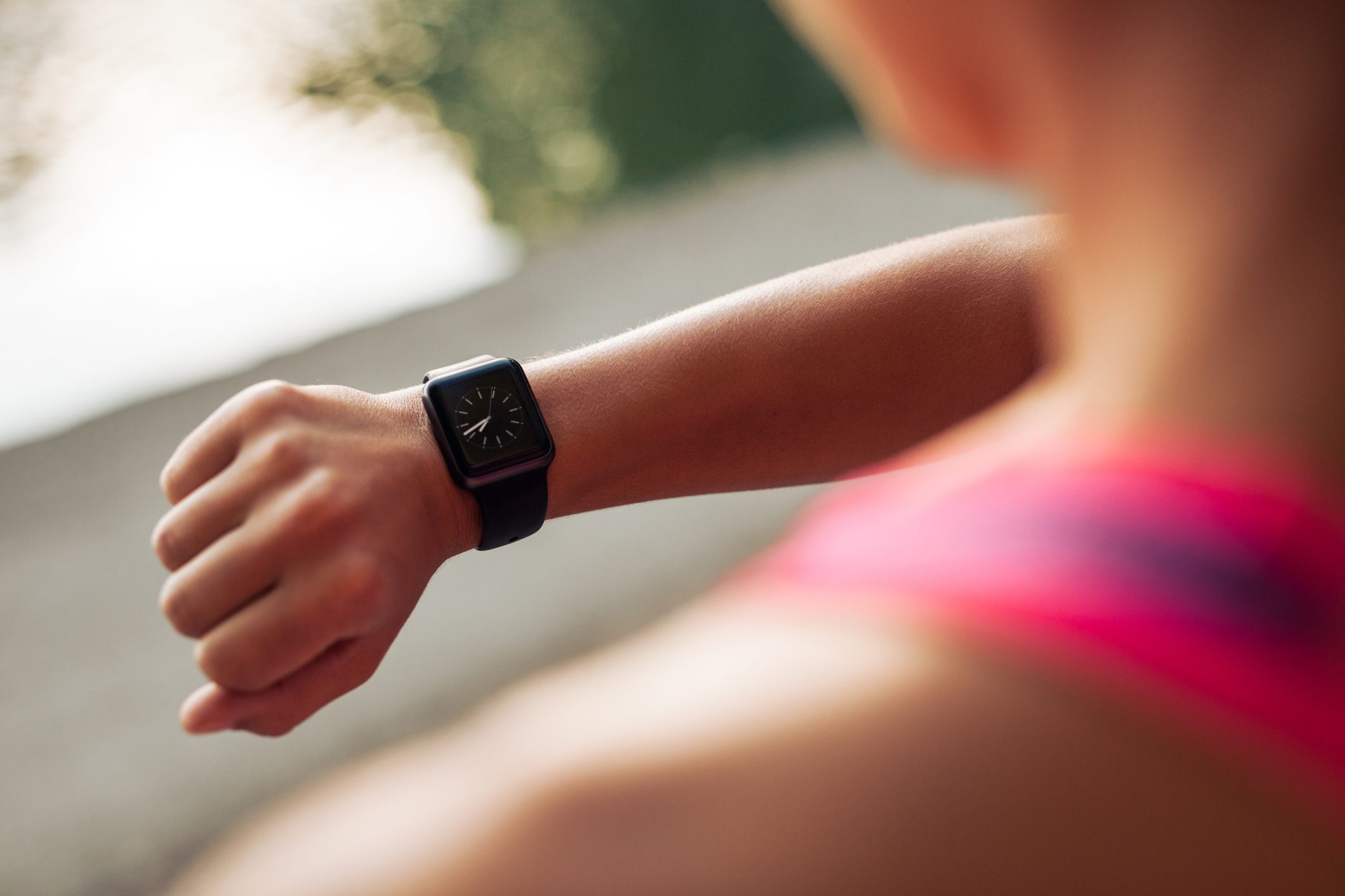 woman checking time on watch while exercising