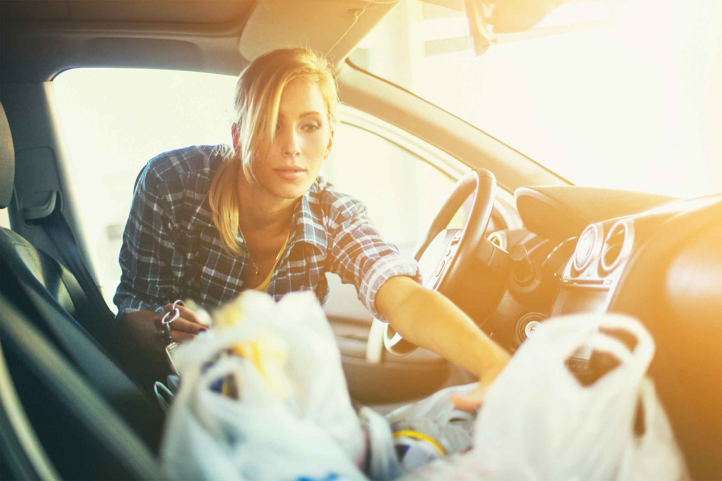 Woman taking groceries out of car