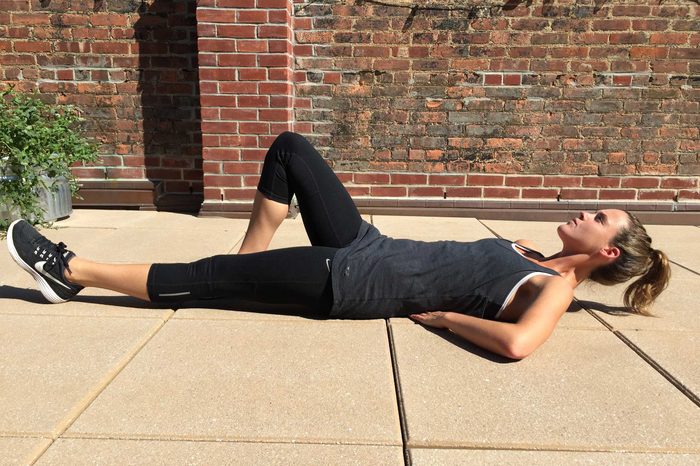 Woman in exercise gear doing the McGill curl up.