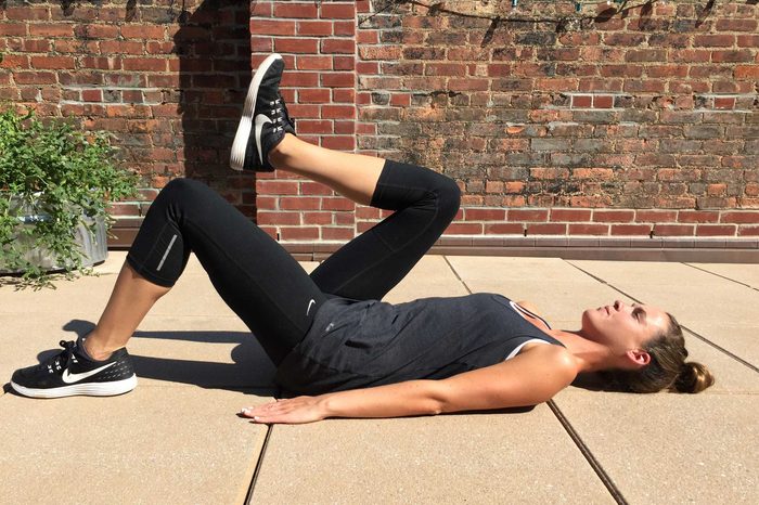 Woman in exercise gear doing marching curls.