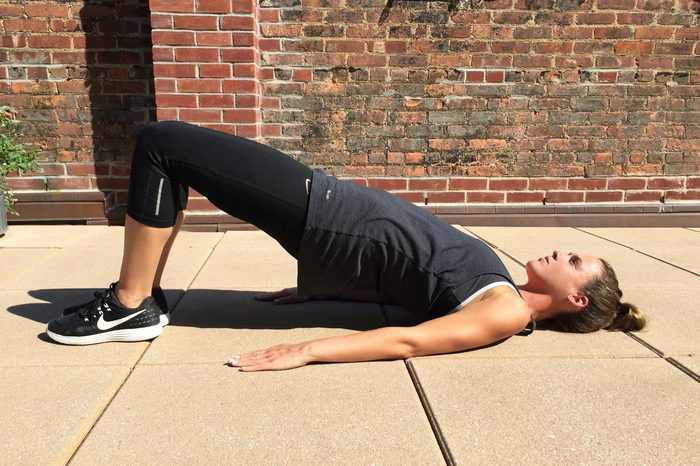 Woman in exercise gear doing core bridge exercises.