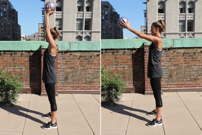 Woman in exercise gear doing a soccer throw core exercise.