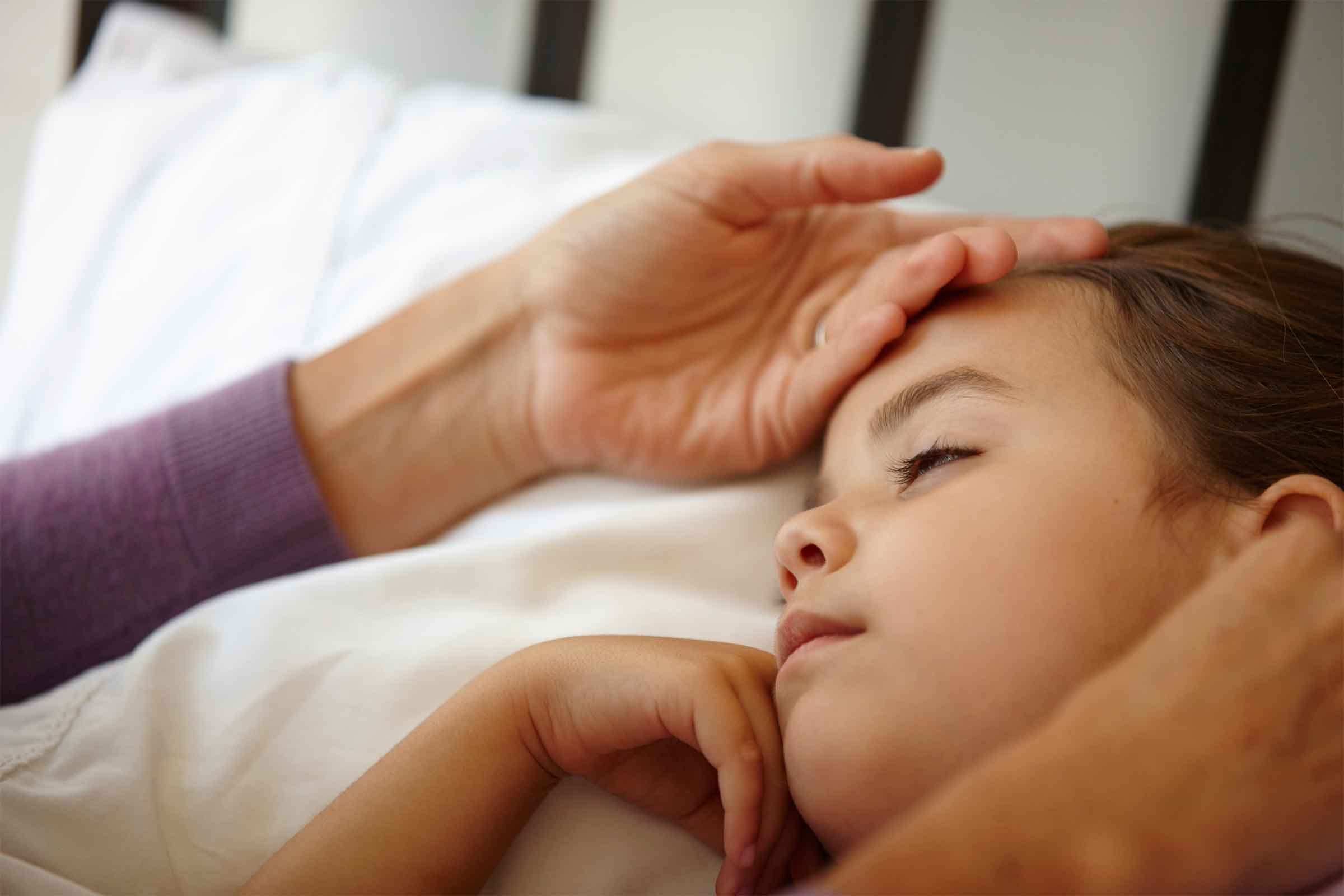 woman with back of hand on young girl's head