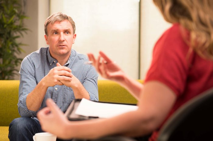 Man talking to a psychologist with a clipboard.