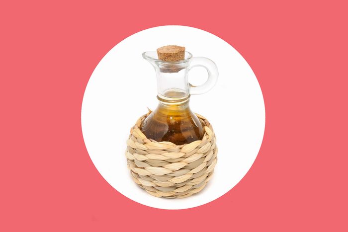 apple cider vinegar in a straw-bottomed glass pourer