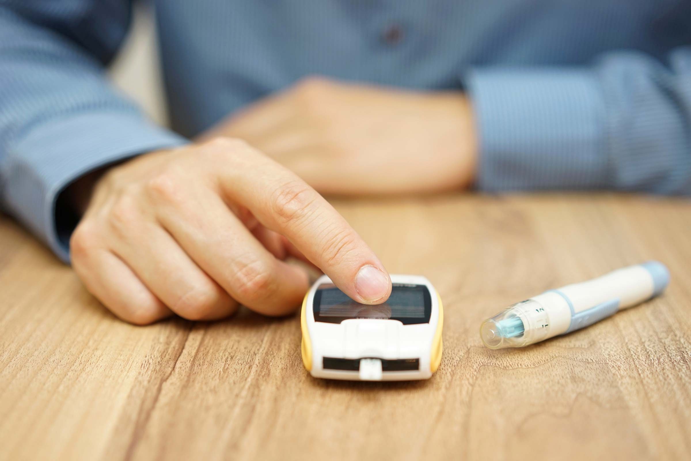 Man using a glucometer to check his blood sugar.