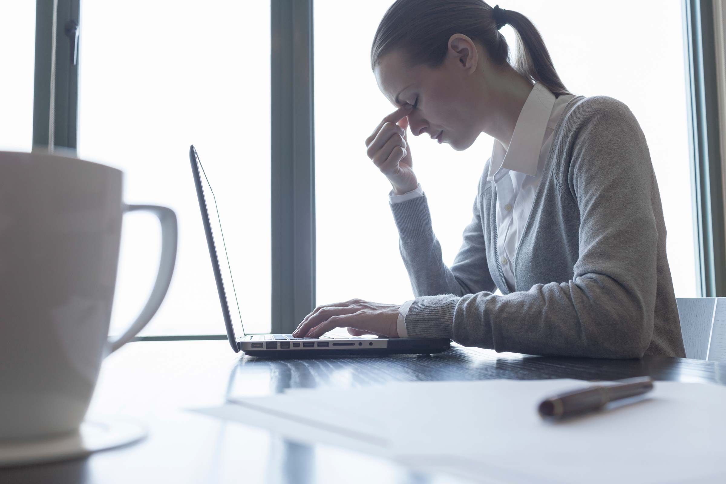 woman with head in hands in office