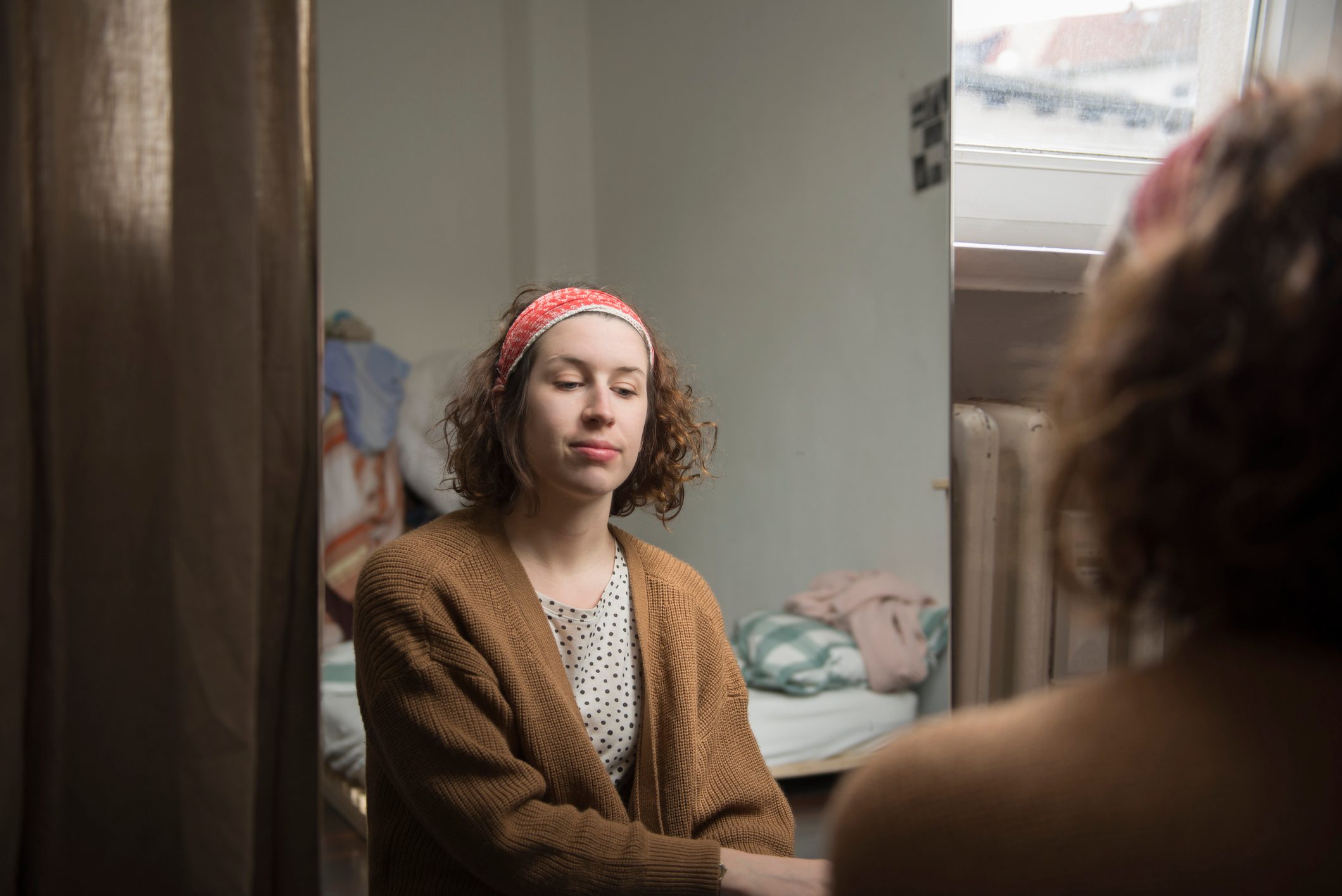 young woman looking in mirror at herself