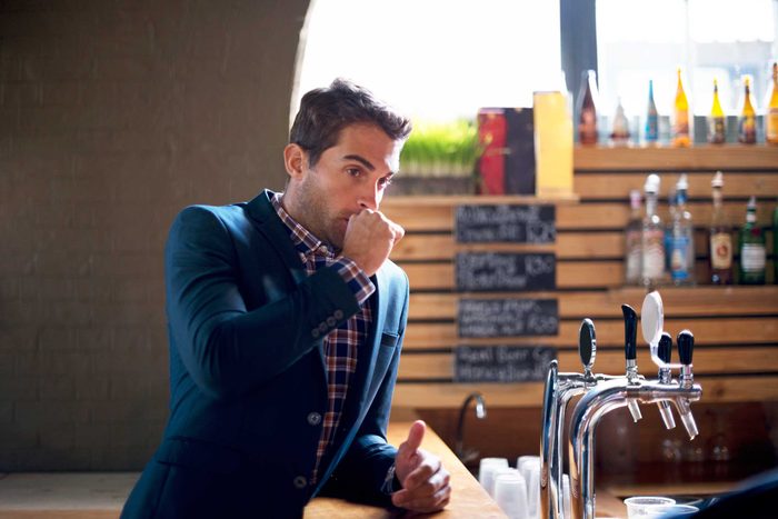 Man with his hand at his mouth.