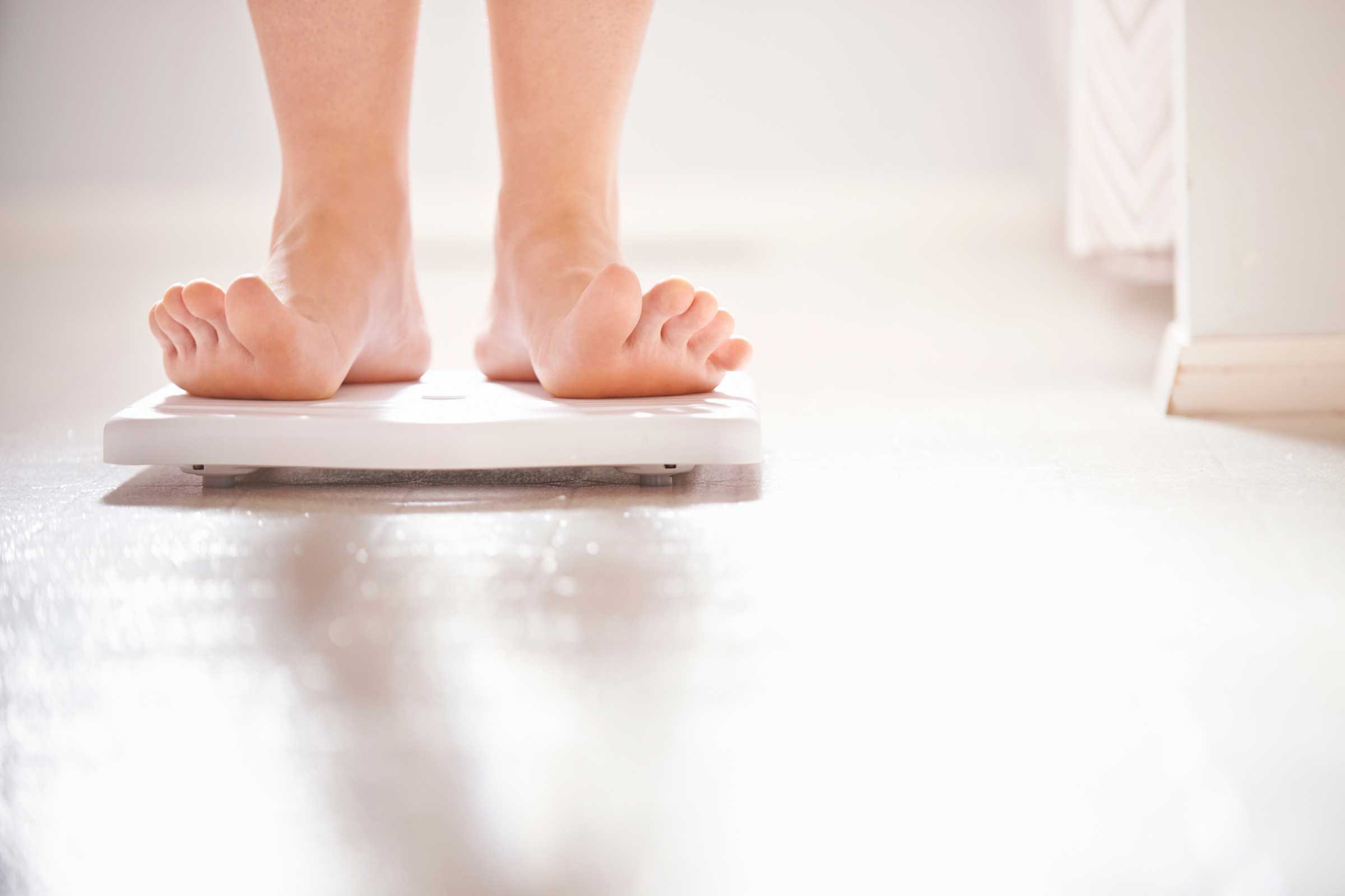 close up of feet standing on a scale