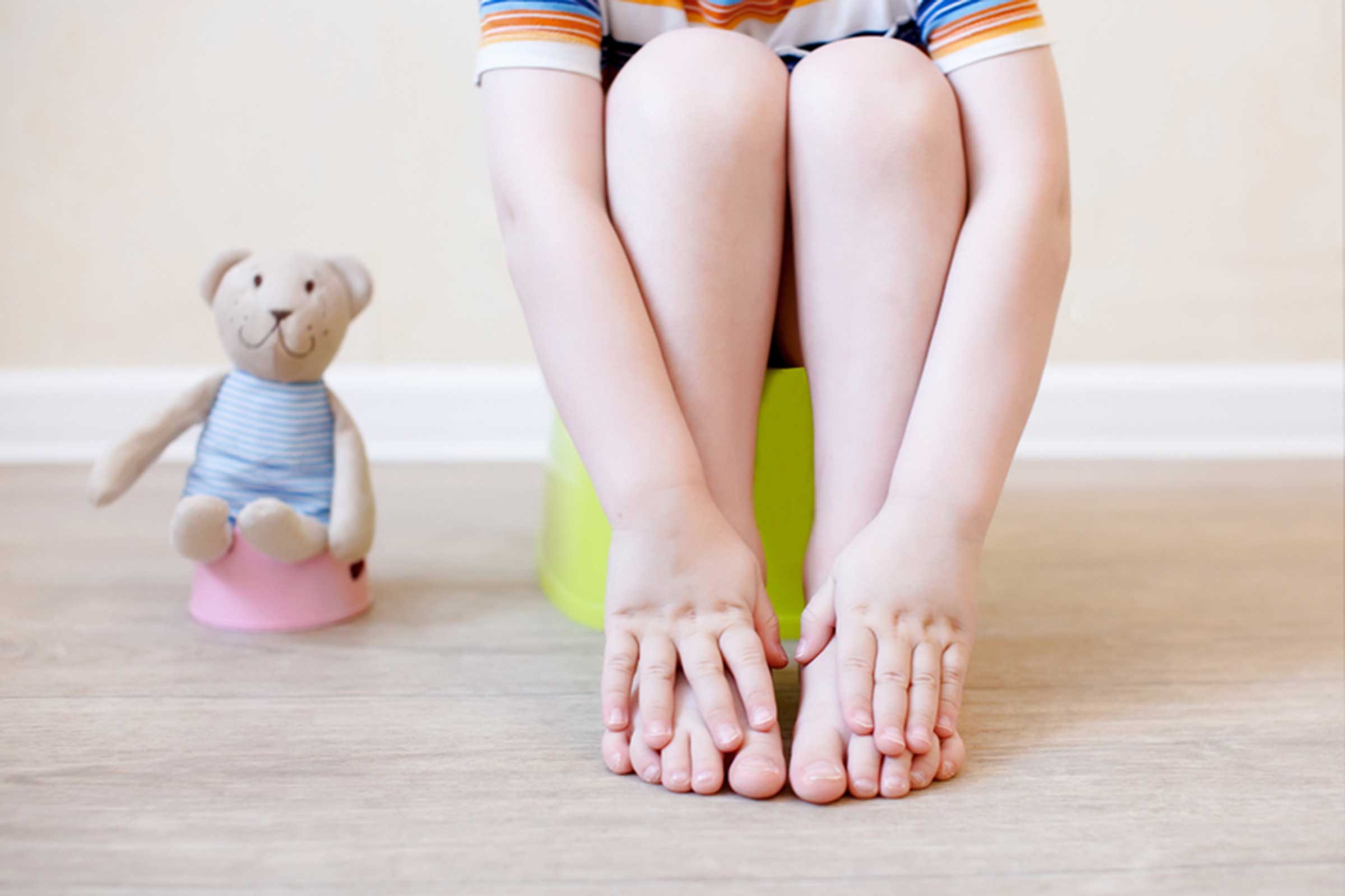 toddler on a training potty next to teddy bear on a mini potty
