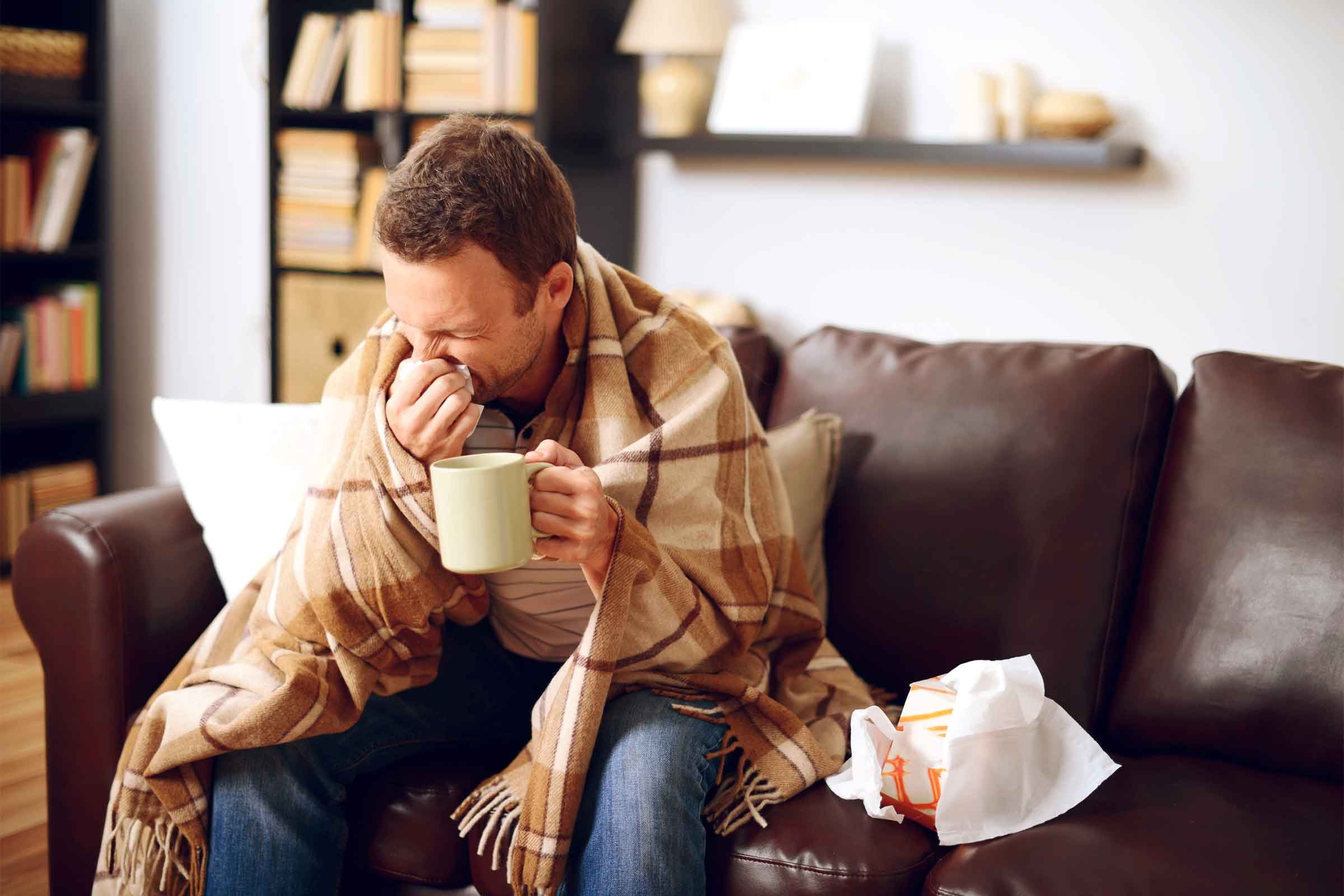 man with blanket on couch