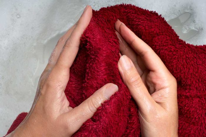 hands holding wet washcloth