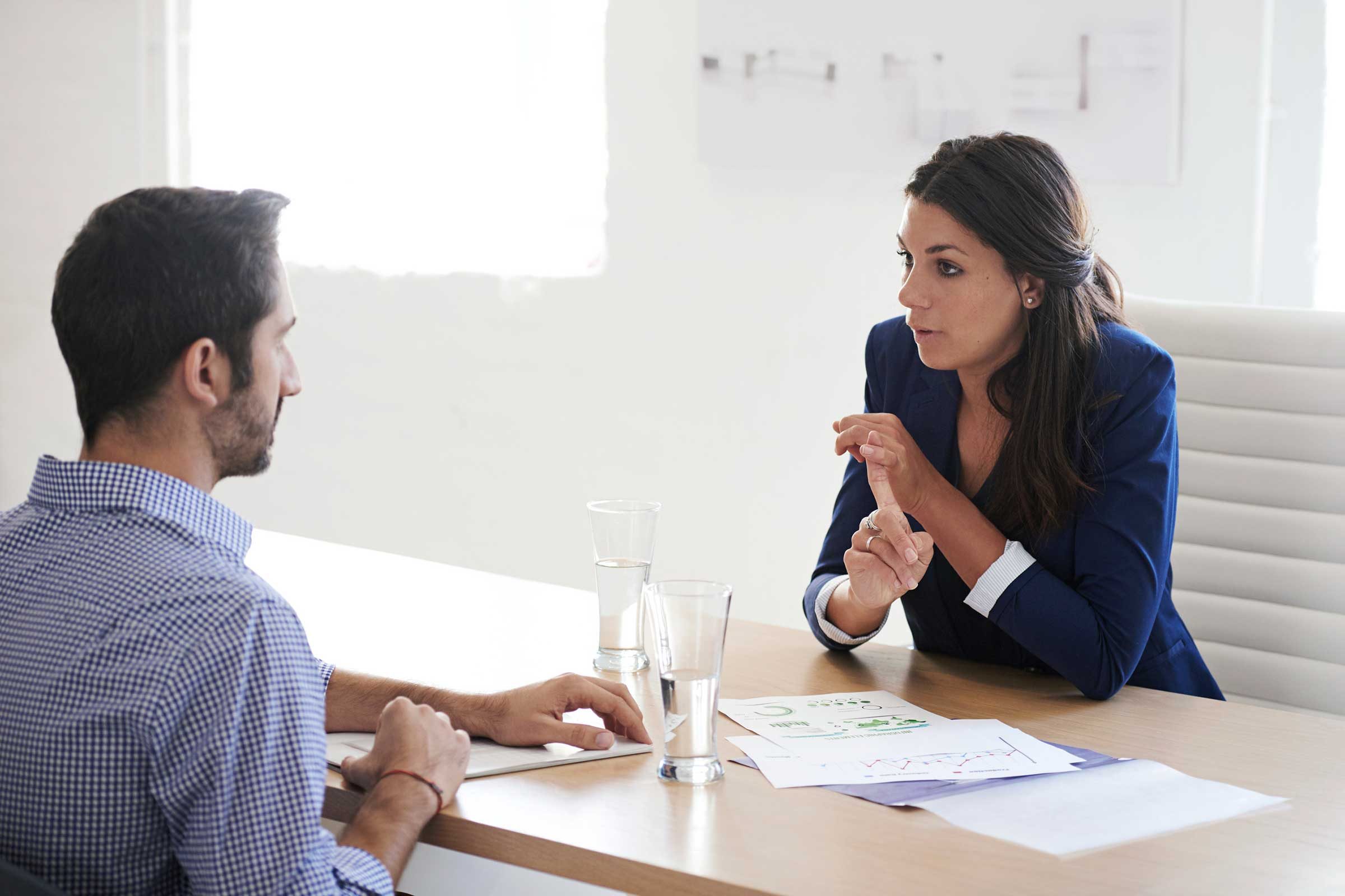 Woman talking to a man across from office desk