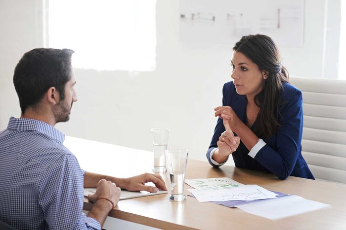 Woman talking to a man across from office desk
