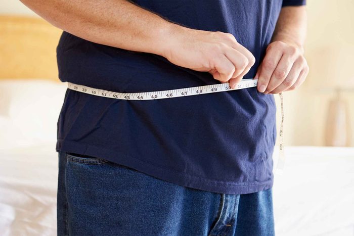 Man measuring his waistline