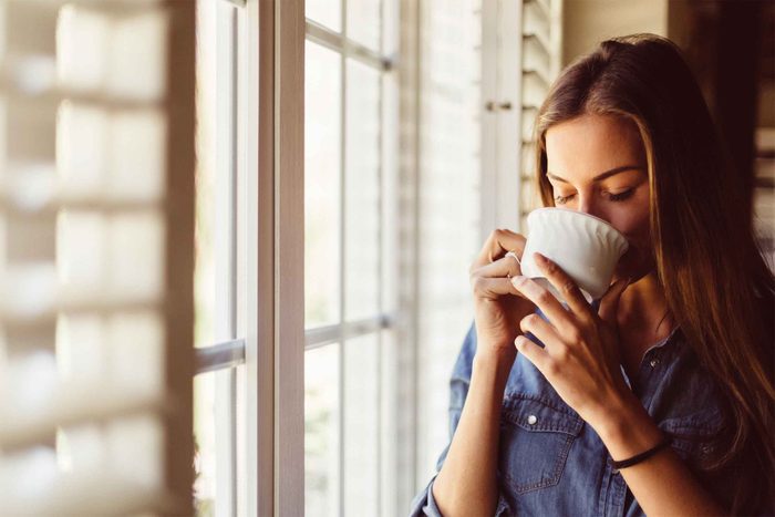 woman drinking tea by a window