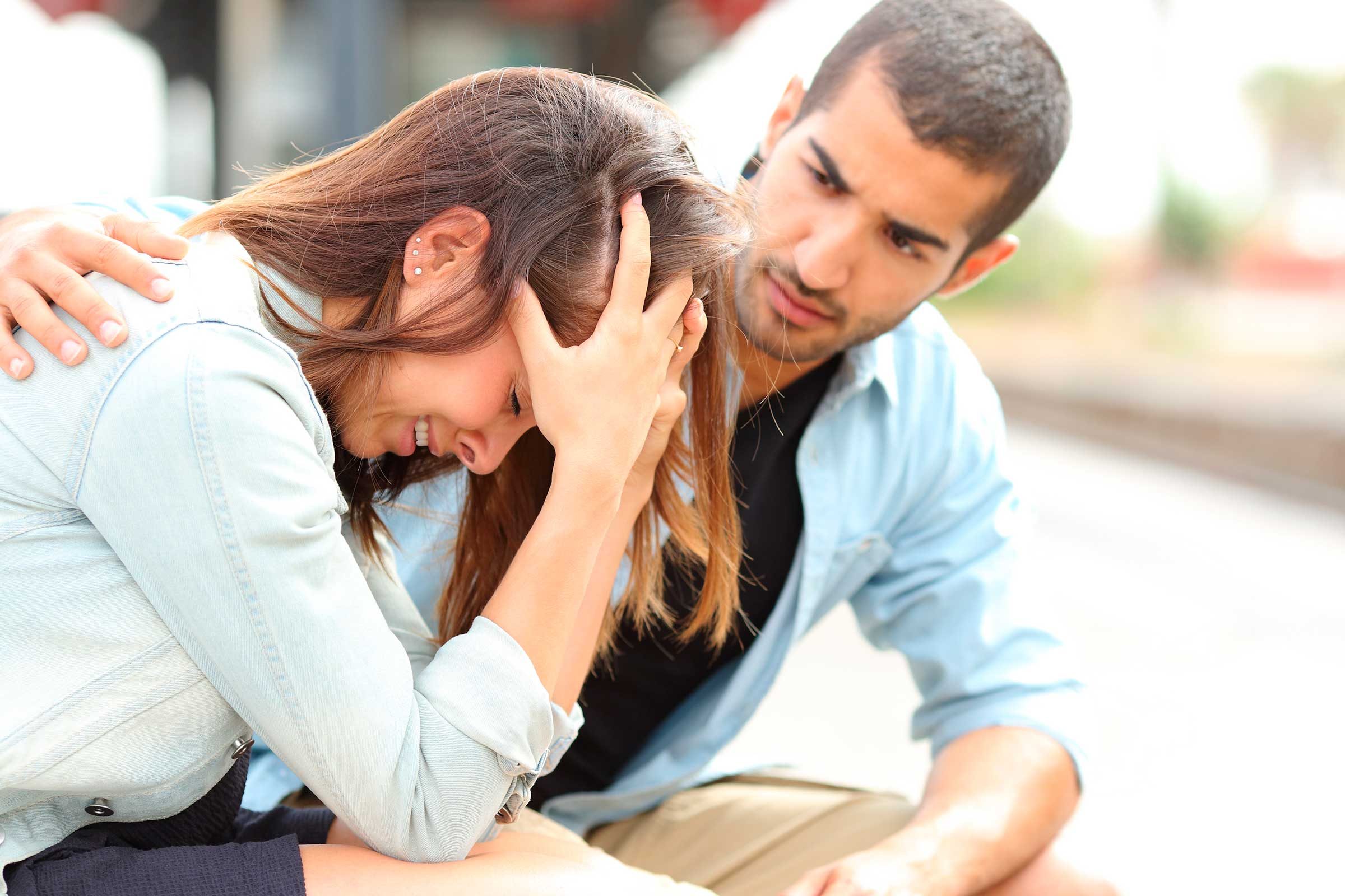 Man with hand on back of upset woman