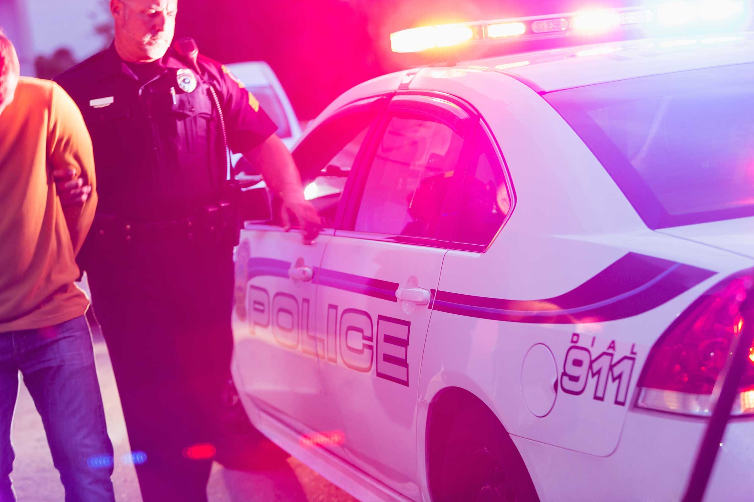 Police officer escorting person to his cruiser