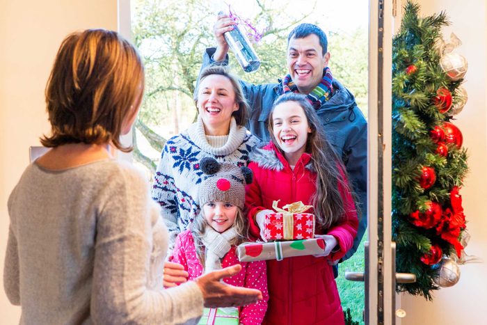 woman greeting family at the door