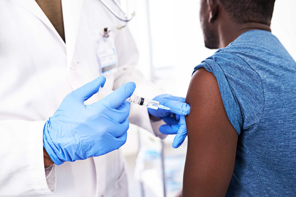 doctor administering a shot to African American man
