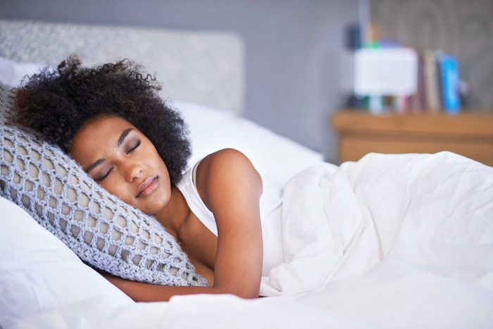 African American woman sleeping in her bed.