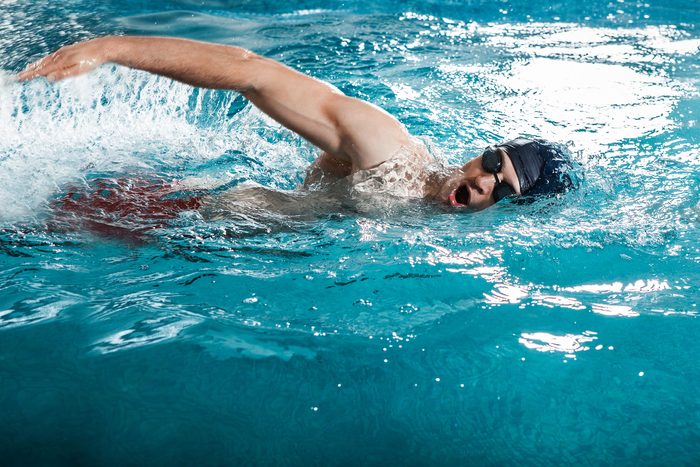 man swimming the crawl in a pool