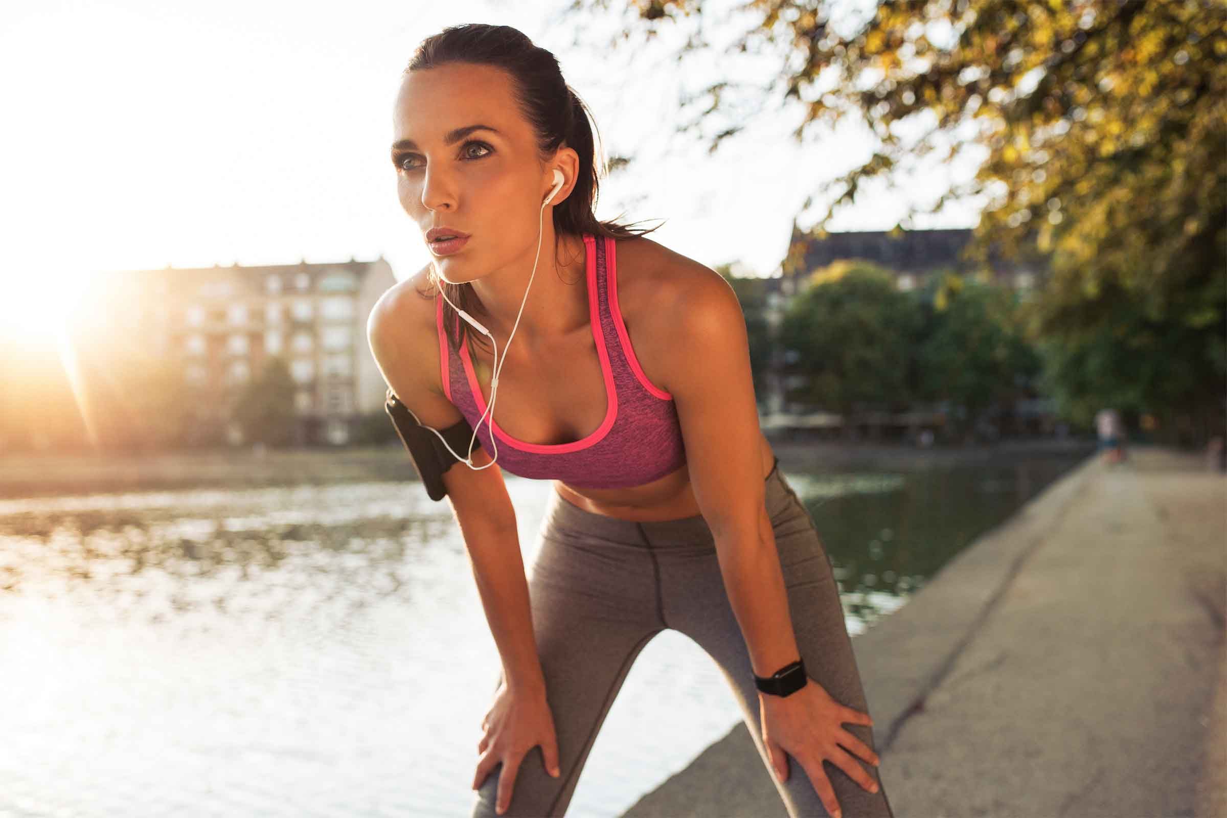 exercising woman taking a breather next to a river