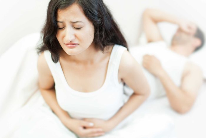 unhappy woman holding gut