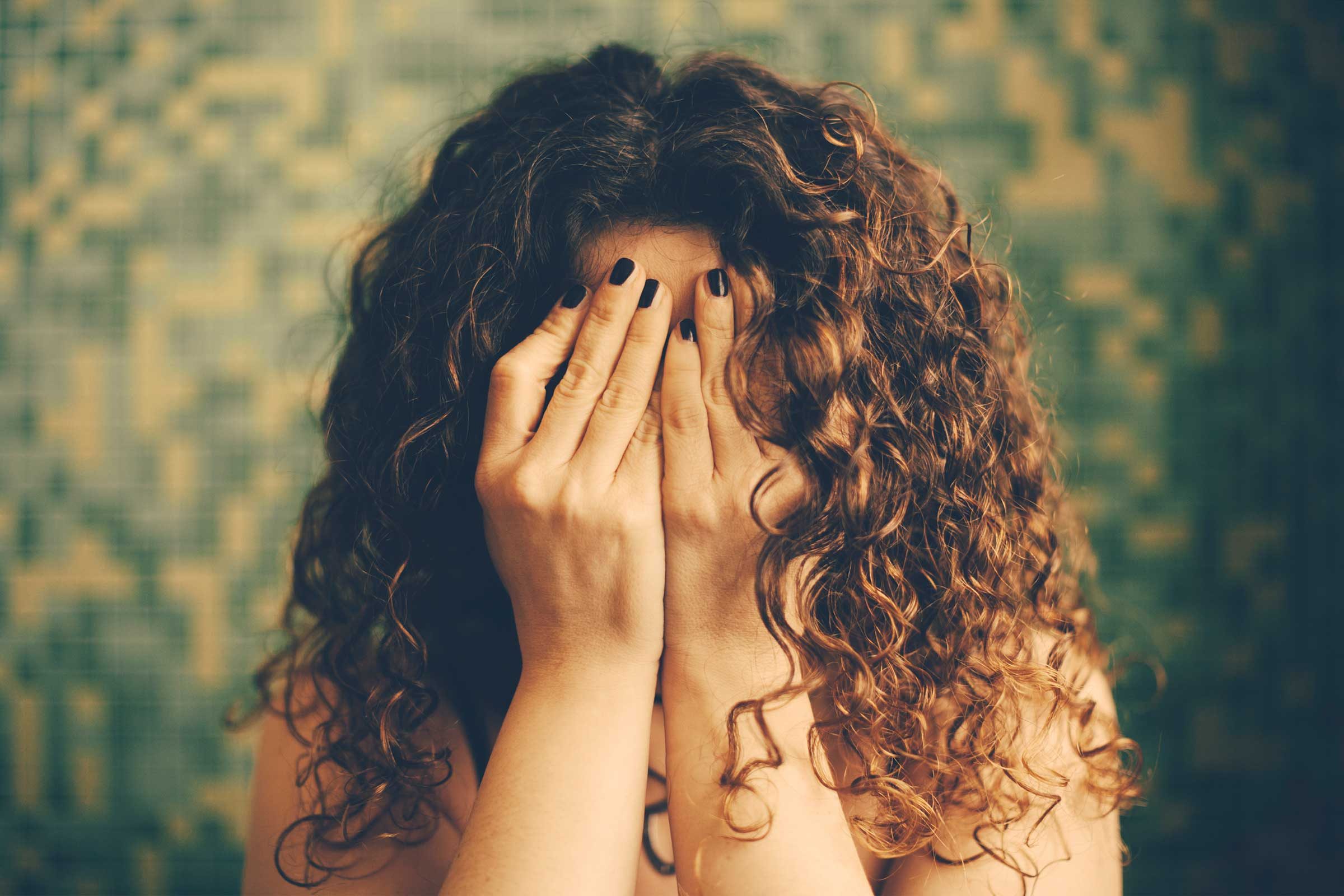 woman covering her face with her hands