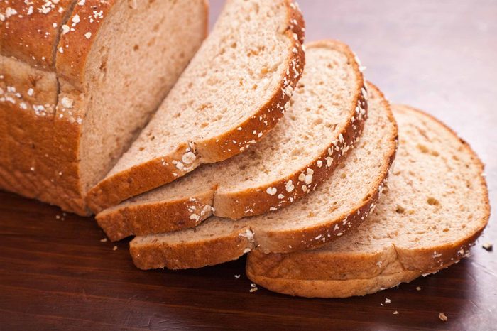 Sliced multigrain bread on a wooden tabletop.