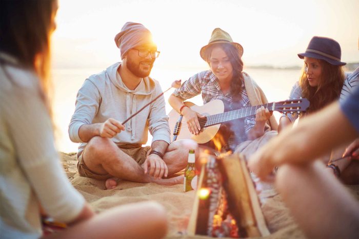 Friends by a campfire on a beach