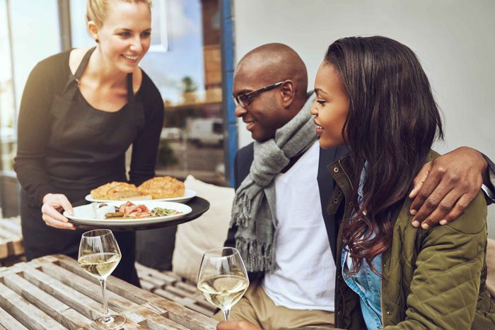 waiter serving food to couple