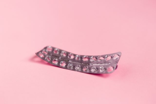 Empty strip of birth control pills on pink background