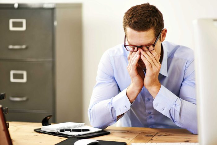 man rubbing his eyes