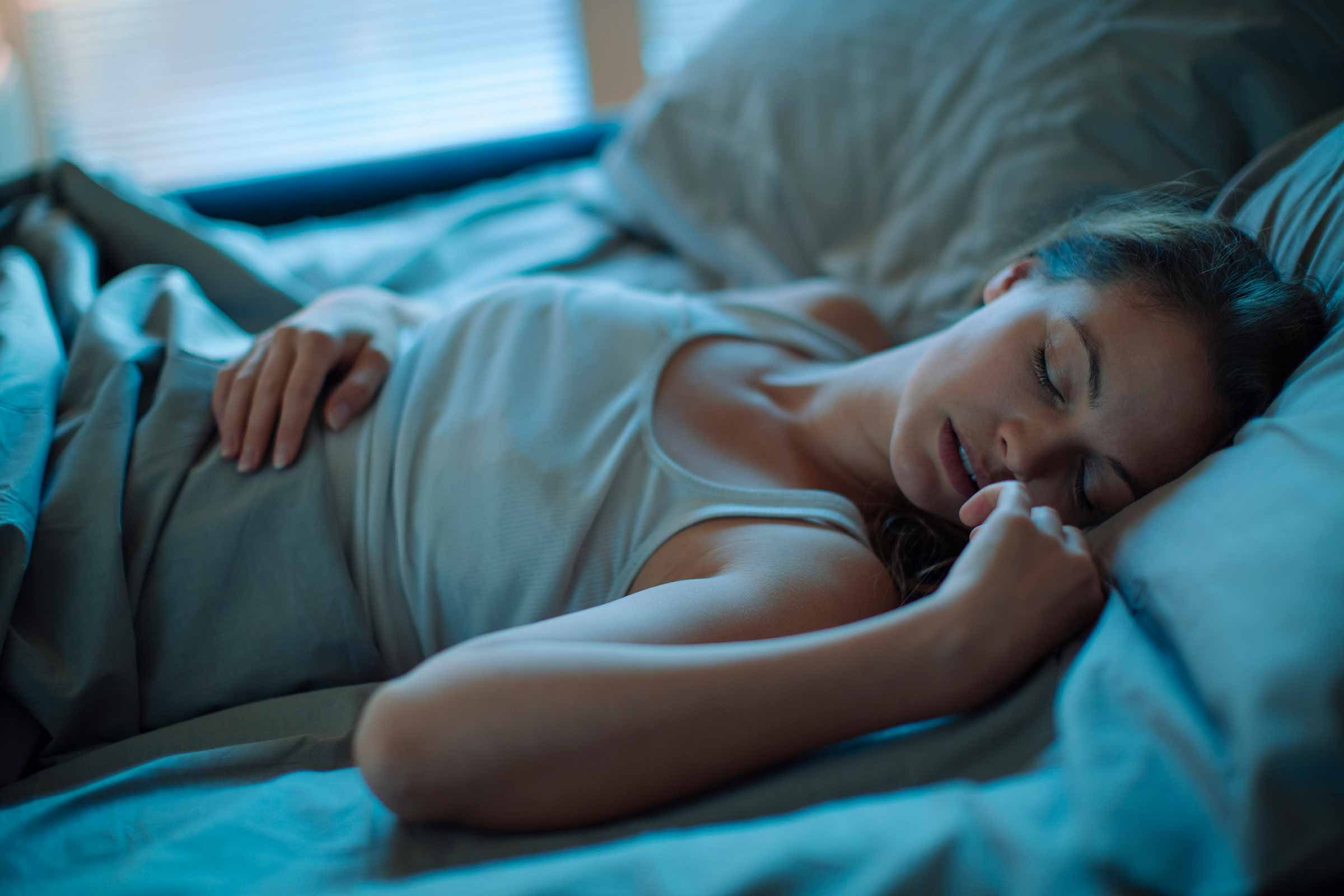 woman sleeping on her back in bed