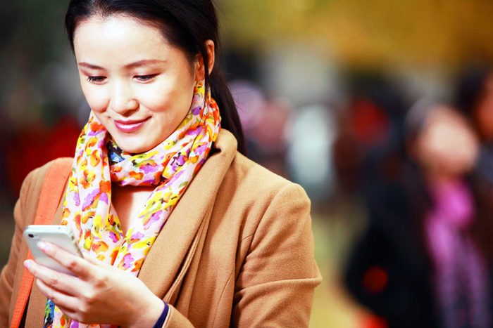 smiling woman look at phone in her hand