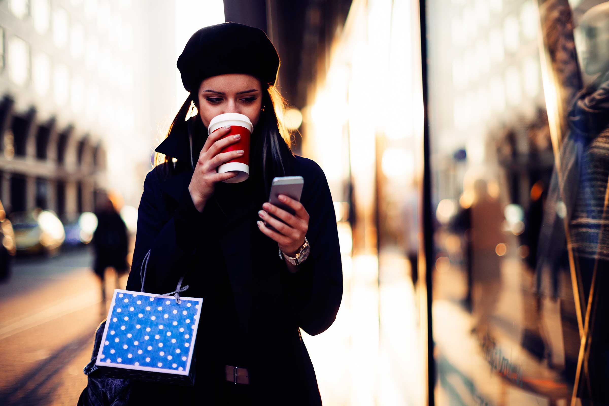 woman drinking coffee while shopping