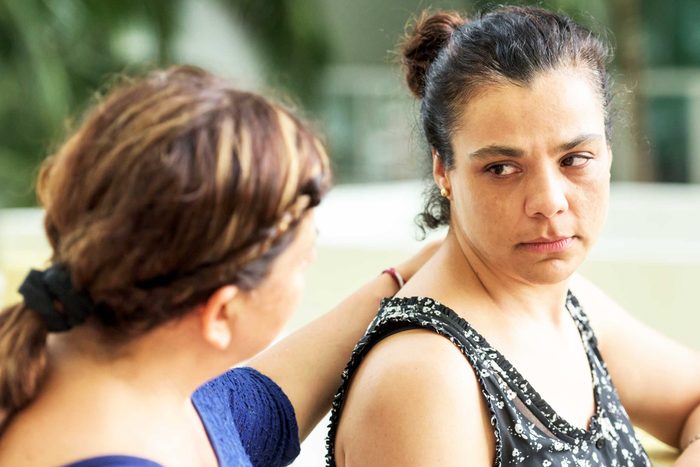 woman with hand on back of an upset woman