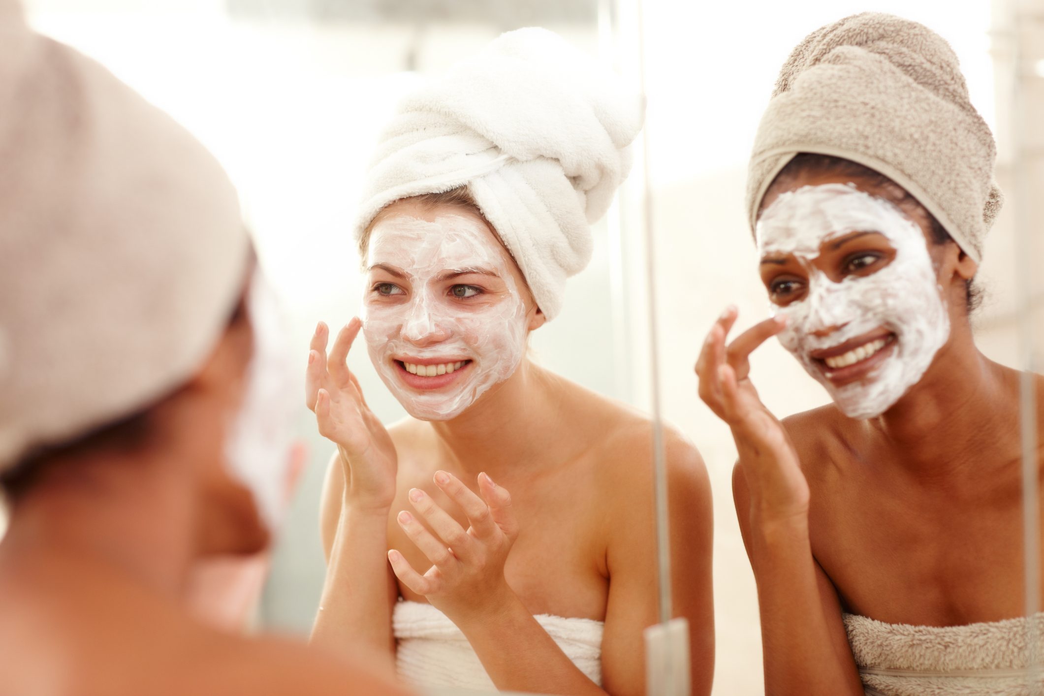 two young women applying face masks