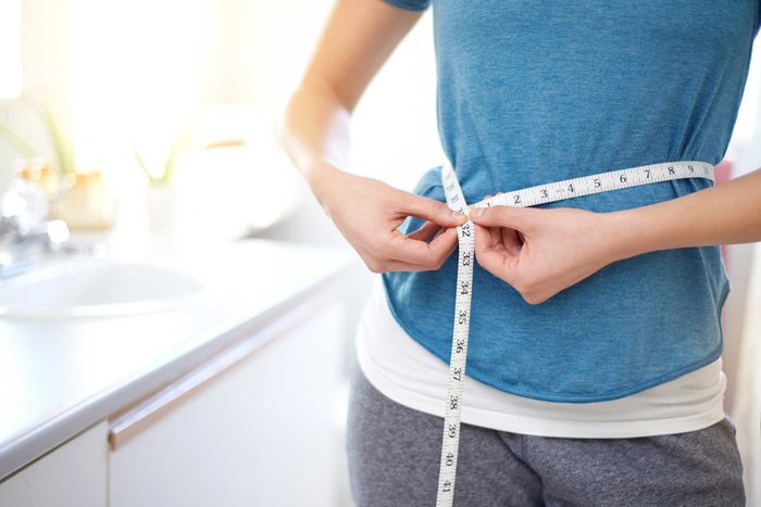 woman with measuring tape around her waist