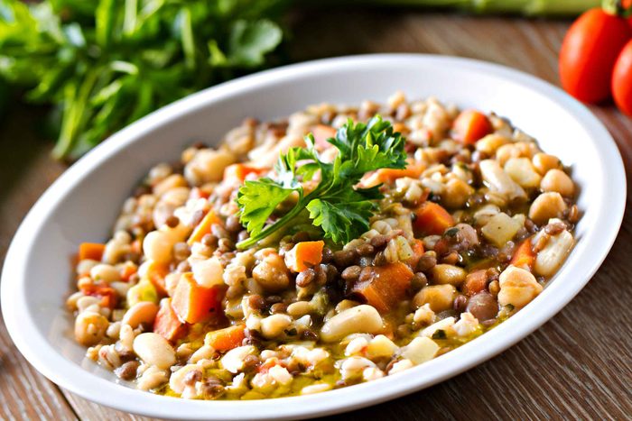 bowl of lentil soup with carrots and parsley on top