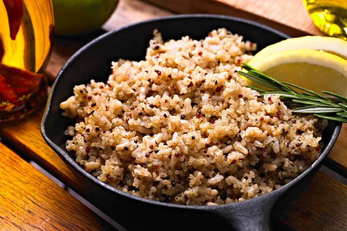 quinoa in a bowl garnished with lemon slices and rosemary