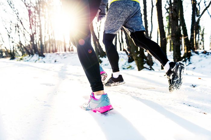 runners' feet in snowy woods