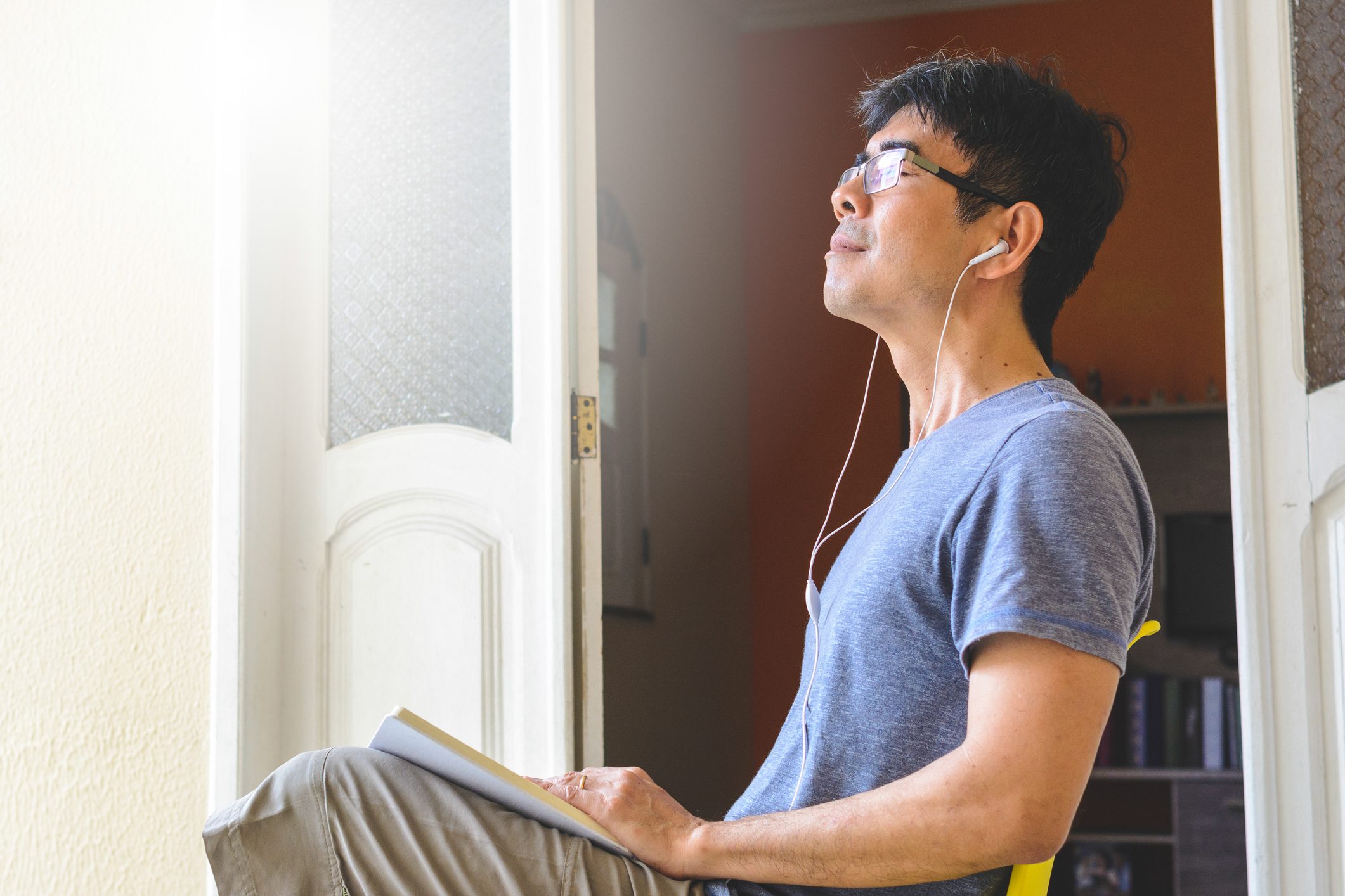 man taking a deep breath and relaxing at home