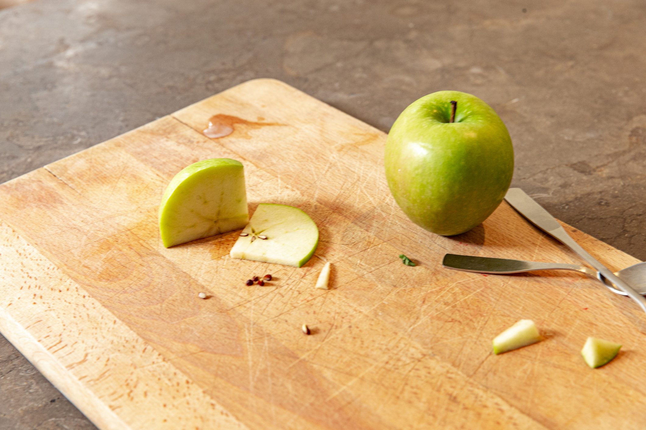 green apple on cutting board in kitchen