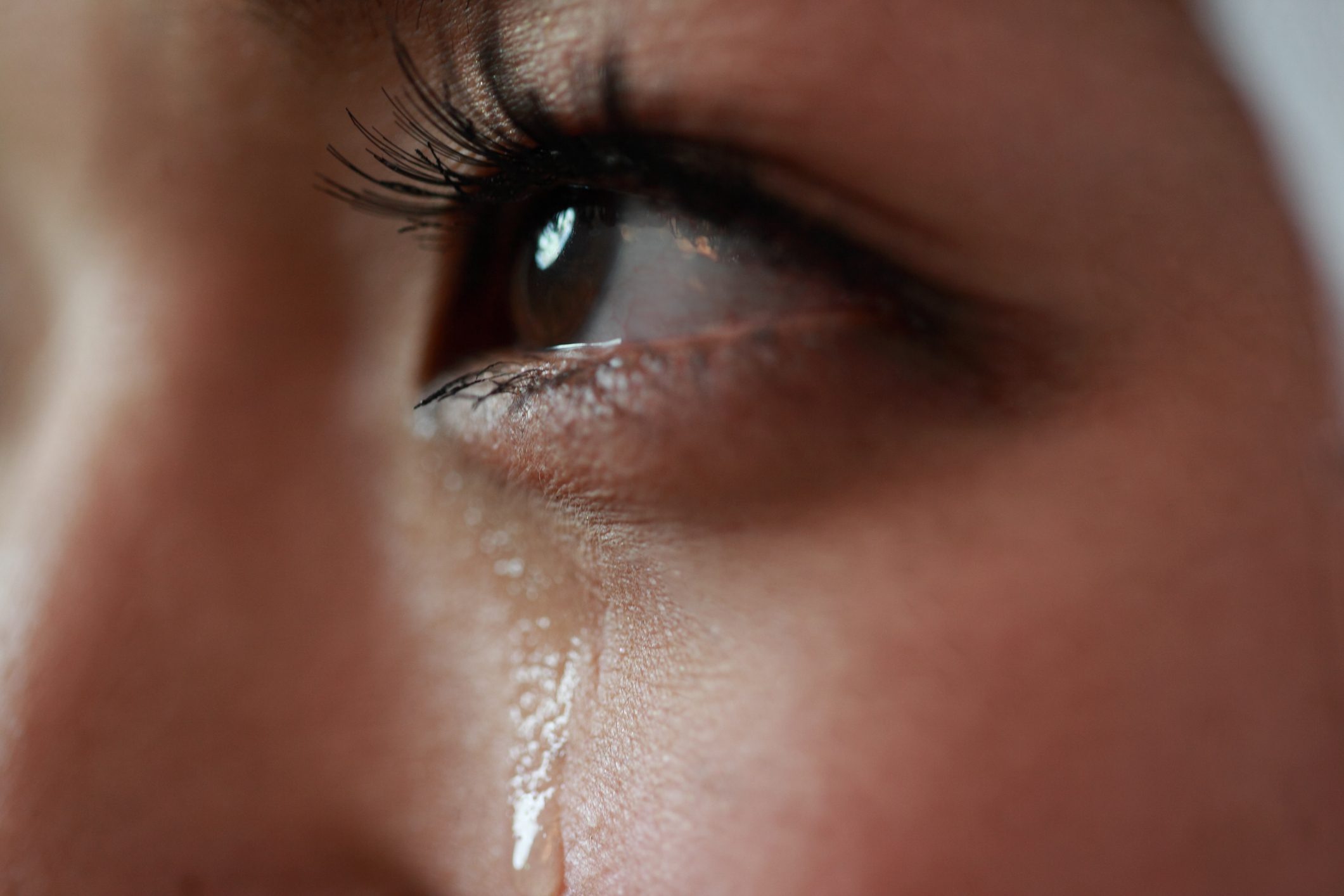 close up of tear streaming down young woman's face